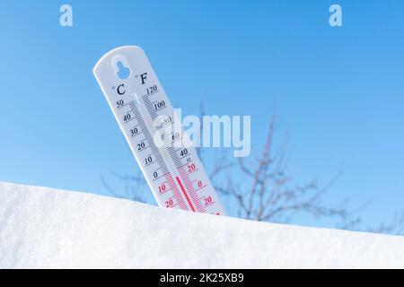 Das Thermometer liegt im Winter auf dem Schnee und zeigt eine niedrige negative Lufttemperatur an. Meteorologische Verhältnisse im rauen Klima in den nördlichen Regionen und in der Umwelt. Klimawandel auf der Erde Stockfoto