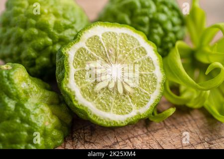 Frische Bergamotte Früchte mit in zwei Hälften geschnitten auf Holz Hintergrund. Stockfoto