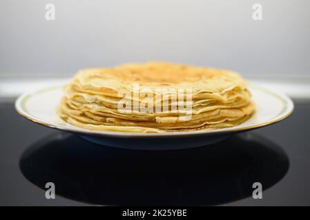 Stapel von Crepes oder dünnen Pfannkuchen auf einem Teller Stockfoto