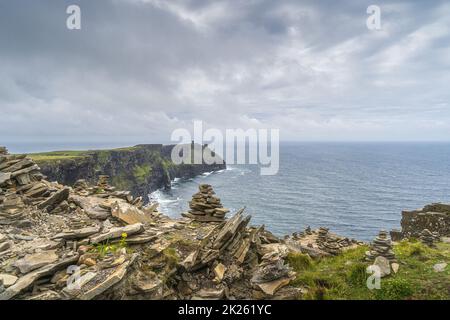 Felsbalancierung am Rande der berühmten Cliffs of Moher, Irland Stockfoto