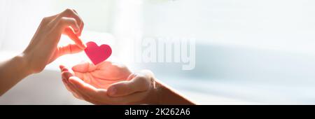 Frau mit Herz auf der Hand Stockfoto