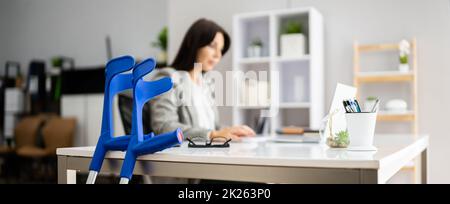 Arbeiter Mit Krücken Am Arbeitsplatz Stockfoto