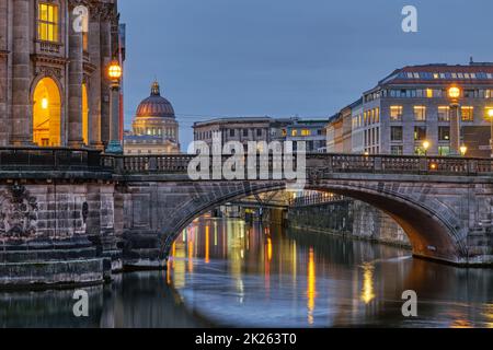 Blick entlang der Museumsinsel in Berlin bei Dämmerung mit der Kuppel des wiederaufgebauten Stadtpalastes im Hintergrund Stockfoto