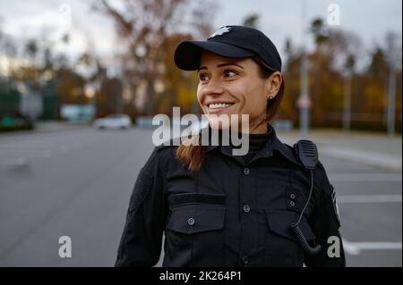 Porträt einer lächelnden Polizistin auf der Straße Stockfoto
