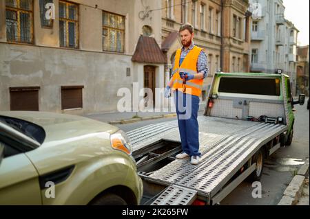 Ein Straßenarbeiter leitet den Evakuierungsvorgang Stockfoto