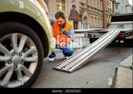 Straßenarbeiter, der das Auto für die Evakuierung vorbereitet Stockfoto