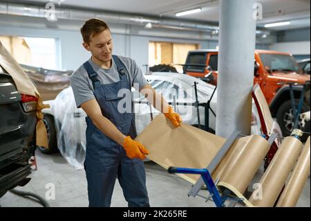 Autoreparaturdienst Arbeiter nimmt Geschenkpapier Stockfoto