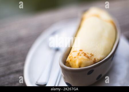 Banana Crepe süß Dessert Objekt Stillleben. Die Kreppe in die Keramik-Behälter Schüssel Bananenform Form Design. Stockfoto