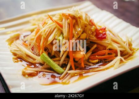 Papaya Salat thai und asia Essen am besten Gericht auf weiß Keramikplatte Objekt Stillleben Stockfoto