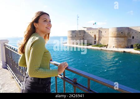 Porträt eines lächelnden entspannten Reisenden Frau Blick Taranto Stadt von der Küste, Apulien, Italien Stockfoto