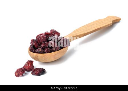 Ein paar getrocknete Preiselbeeren in einem Holzlöffel auf weißem Hintergrund. Köstliche Beeren Stockfoto