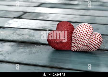 3D Illustration.Valentinstag Konzept. Hand machen zwei rote Herz auf Holztisch Stockfoto