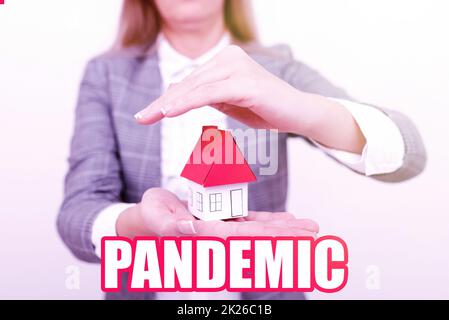 Textzeichen mit Pandemie. Geschäftsidee tritt in einem großen Bereich auf, der einen hohen Anteil der Bevölkerung betrifft Eine junge Dame Orbusinesswoman Holding oder Presecting Home in Business Outfit Stockfoto