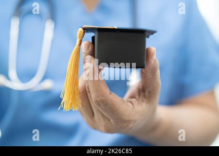 Asiatische Arzt Studie lernen mit Abschluss GAP Hut in Krankenhausstation, clever hell Genie Bildung Medizin Konzept. Stockfoto