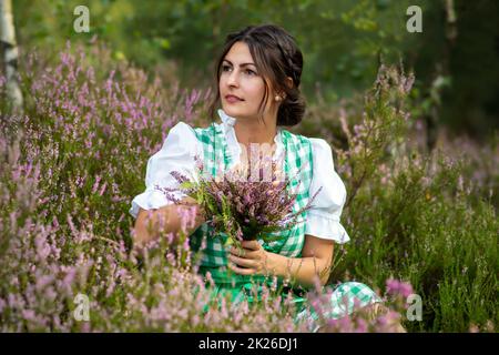 Hübsches Mädchen mit Dirndl im Wald Stockfoto