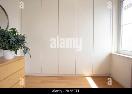 Zimmer mit Einbauschrank in Weiß, modernem Design im neuen Haus, stilvoller Einrichtung Stockfoto