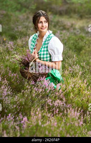 Natürliche Mädchen mit Dirndl in Heide Stockfoto
