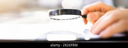 Geschäftsmann, Der Sich Durch Vergrößerung Dokumente Ansieht Stockfoto