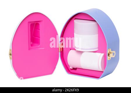 Nahaufnahme einer geöffneten dekorativen Kosmetikbox oder Geschenkbox mit etikettsfreien pink-weißen Behältern, isoliert auf weißem Hintergrund. Makro. Stockfoto