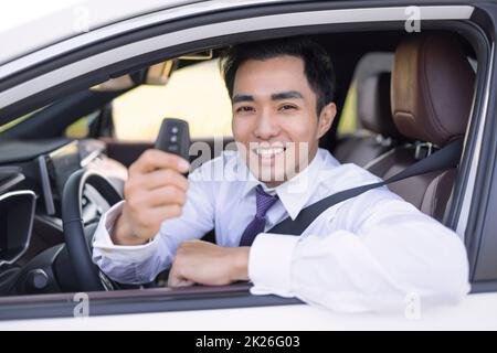 Geschäftsmann lächelt und zeigt Autoschlüssel Stockfoto