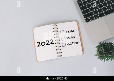 2022 Neujahr Ziel-, Plan-, Aktions-Konzepte mit Text auf Notizblock und Computer-Laptop im Hintergrund. Stockfoto