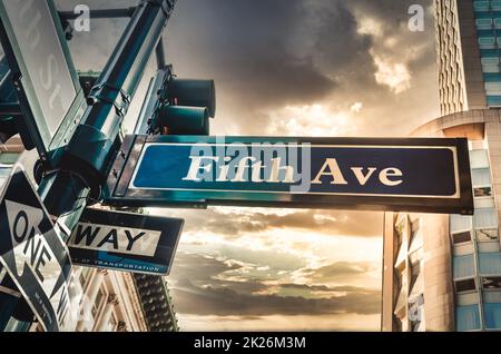 Fifth Ave 5th Ave, New York City-Schild, Blick aus dem niedrigen Winkel mit Sonnenuntergang und Empire State Building im Hintergrund, amerika, usa Stockfoto