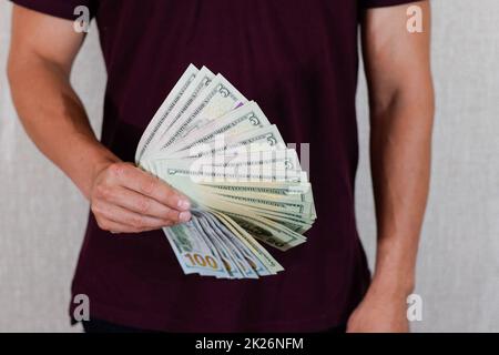 Ein Mann in der Hand hält die Dollar im Fächer. US-Dollar. Stockfoto