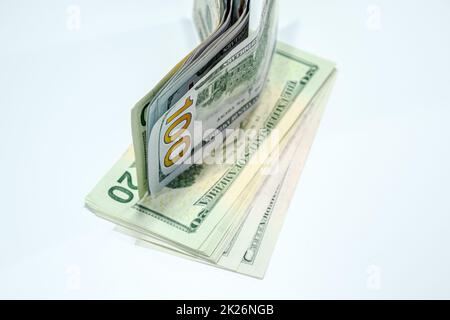 Dollars in einem Gegenwind auf weißem Hintergrund, eine Menge Geld in einem Umschlag. Stockfoto