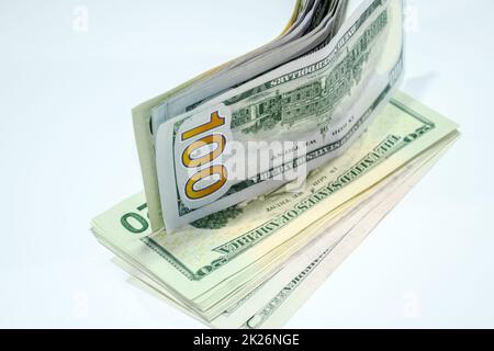 Dollars in einem Gegenwind auf weißem Hintergrund, eine Menge Geld in einem Umschlag. Stockfoto