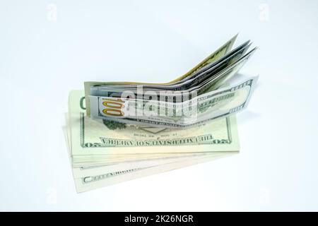 Dollars in einem Gegenwind auf weißem Hintergrund, eine Menge Geld in einem Umschlag. Stockfoto