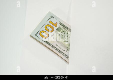 Dollars in einem Gegenwind auf weißem Hintergrund, eine Menge Geld in einem Umschlag. Stockfoto