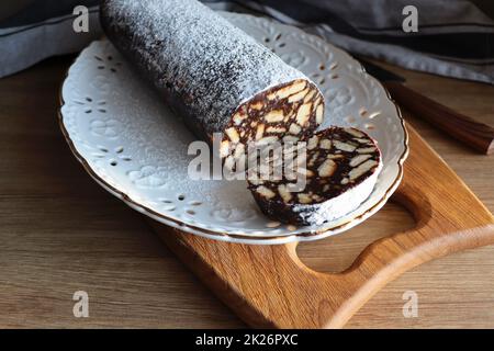 Fauler Kuchen oder Mosaikkuchen . Hausgemachter, nicht gebackener Schokoladenkuchen auf einem Holztisch Stockfoto