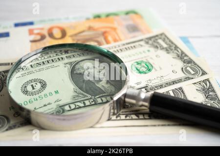 Lupe mit Hintergrund für Euro- und US-Dollar-Banknoten, Bankkonto, Investment Analytic Research Data Economy, Handel, Unternehmenskonzept. Stockfoto