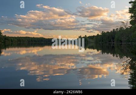 Abendwolken auf einem ruhigen Wildnissee Stockfoto