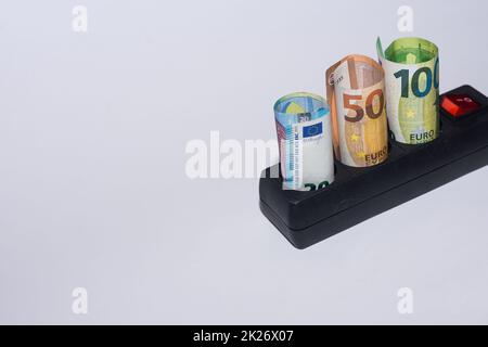 Energieverbrauch und Anstieg der Strompreise drei Euro in einer Steckdosenleiste ganz oben Stockfoto