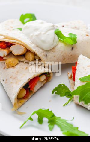 Tortilla gefüllt mit Hühnerfleisch, rotem Pfeffer und Bohnen Stockfoto