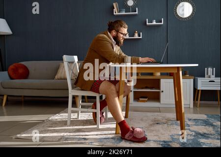 Fokussierter intelligenter Kerl Geek Experte, der online arbeitet Stockfoto