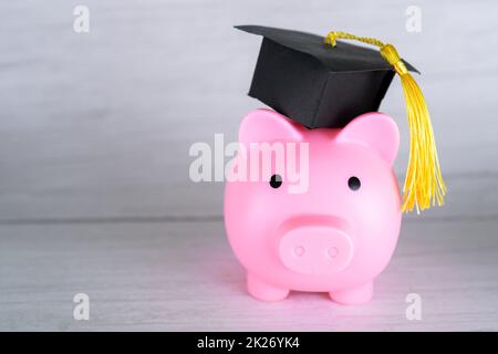 Sparschwein mit Abschlusskappe, Business Finance Bildung Geld sparen Stipendium Konzept. Stockfoto