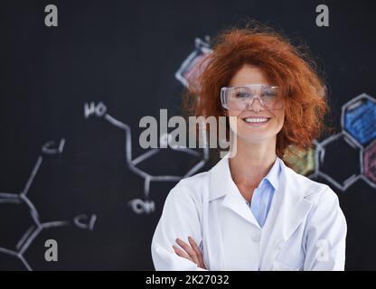 Ich habe alle Antworten erhalten. Eine unordentliche Wissenschaftlerin, die stolz in ihrem Labor steht. Stockfoto