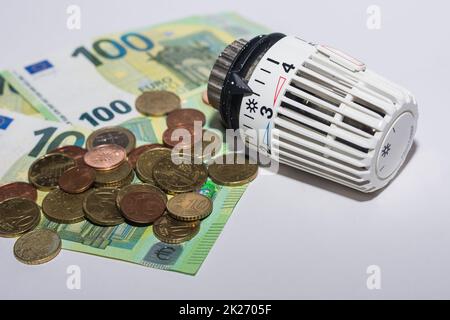 Die Energiepreise steigen und der Energieverbrauch wird durch einen Thermostatregler aus dem Heizen mit Euro-Banknoten und -Münzen geregelt Stockfoto