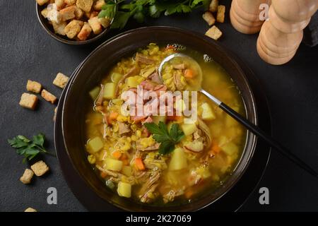Linsen Erbsensuppe mit Speck, gebratene Zwiebel und Croutons Stockfoto