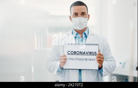 Waren alle gefährdet. Aufnahme eines Wissenschaftlers mit einem Schild mit CORONAVIRUS – SIE KÖNNTEN ALS NÄCHSTES in einem Labor dabei sein. Stockfoto