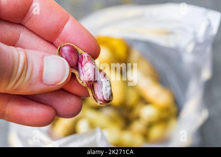 Erdnuss mit Schale und roter Haut in der Hand Bangkok Thailand. Stockfoto