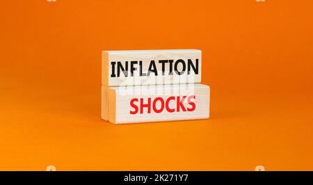 Symbol für Inflationsschocks. Konzept Worte Inflation Schocks auf Holzblöcke. Schöne orange Tisch orange Hintergrund. Die Inflation der Unternehmen erschüttert das Konzept. Stockfoto