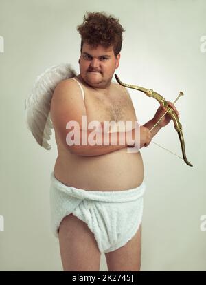 Er bringt die Liebe zum Valentinstag mit. Ein übergewichtiger Mann, der als Cherub gekleidet war, während er isoliert war. Stockfoto