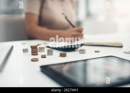 Arbeiten an ihren finanziellen Zielen. Nahaufnahme einer unkenntlichen Geschäftsfrau, die in einem Büro die Finanzen berechnet. Stockfoto