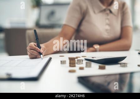 Arbeiten an der Bilanz ihres Unternehmens. Nahaufnahme einer unkenntlichen Geschäftsfrau, die in einem Büro die Finanzen berechnet. Stockfoto