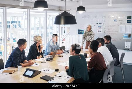 Alles bereit für einen gemeinsamen Erfolg. Aufnahme einer Gruppe von Geschäftsleuten, die in einem modernen Büro ein Meeting abhalten. Stockfoto