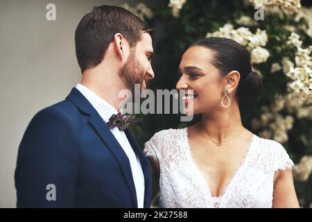 Die Liebe hat uns zusammengebracht. Aufnahme eines glücklichen jungen Paares, das an ihrem Hochzeitstag zusammen posiert. Stockfoto