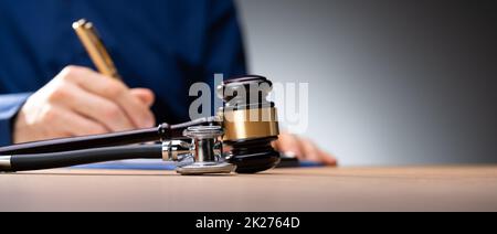 Hammer Mit Medizinischem Stethoskop Auf Holzschreibtisch Stockfoto